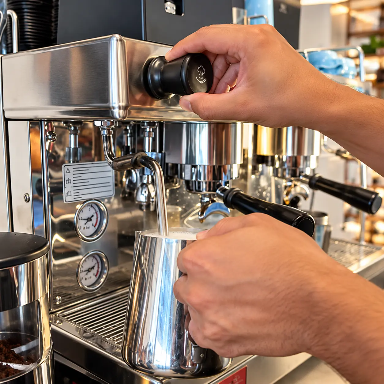 Barista steaming milk at the espresso machine